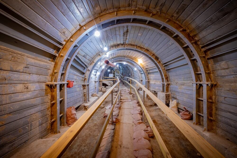 The ancient Pilgrimage Road in Jerusalem showing excavated stone steps that once led from the Pool of Siloam to the Temple Mount, illuminated by modern lighting inside the underground tunnel
